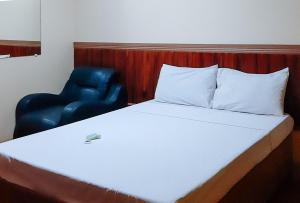 een bed en een stoel in een kamer bij RedDoorz @ Farm Side Hotel Laoag City in Laoag