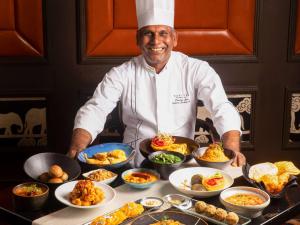 um chef em pé em frente a uma mesa de comida em Sofitel Mumbai BKC em Mumbai