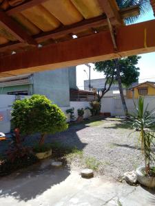 un patio trasero con techo de madera y algunas plantas en Suíte Sunflower 103 en Rio das Ostras