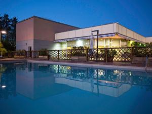 a building with a swimming pool in front of a building at Novotel Caserta Sud in Caserta