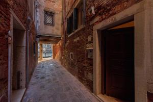 een leeg steegje met een bakstenen gebouw en een deur bij Ca' Emo Palazzo sul Canal Grande in Venetië