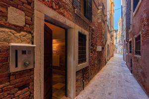 een steeg met een open deur op een bakstenen gebouw bij Ca' Emo Palazzo sul Canal Grande in Venetië