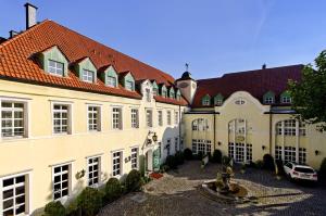 a group of buildings with a fountain in a courtyard at Parkhotel Engelsburg - 4 Sterne Superior in Recklinghausen