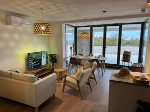 a living room with a couch and a dining room at Brisa Wellness Apartments - clothing optional, DFK, FKK in may, june, september in Labin
