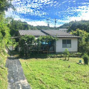 mały biały dom z ogródkiem i domem w obiekcie Naoshima J-House w mieście Naoshima