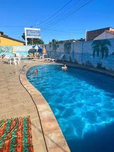 a swimming pool with two people in the water at Pousada Paradise in Alcobaça