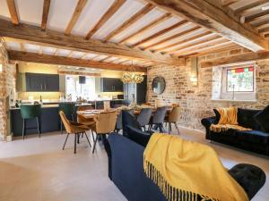 uma sala de estar com mesa e cadeiras e uma cozinha em Wildersley Farm - The Farm House em Belper