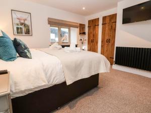 a bedroom with a large bed and a flat screen tv at Rockhill Farmhouse in Craven Arms