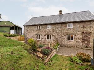 a stone house on a hill with a yard at Rockhill Farmhouse in Craven Arms