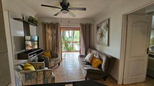 a living room with two couches and a ceiling fan at Pont de Fleur in Hartbeespoort