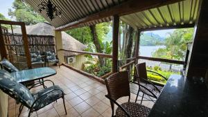 a screened in porch with a table and chairs at Pont de Fleur in Hartbeespoort