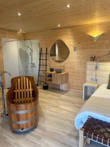 sypialnia z łóżkiem, wanną i lustrem w obiekcie Les Lodges de Malbrough w mieście Aire-sur-la-Lys