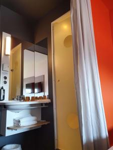 baño con espejo y cortina de ducha blanca en ibis budget Saint Lô en Saint-Lô