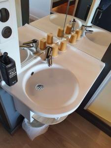 a bathroom with a sink with two mirrors at ibis budget Saint Lô in Saint Lo