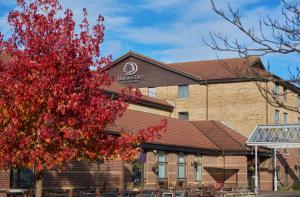 a building with a red tree in front of it at DoubleTree by Hilton Swindon Hotel in Swindon