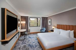 a hotel room with a bed and a flat screen tv at DoubleTree by Hilton Swindon Hotel in Swindon