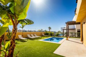 an image of a backyard with a swimming pool and grass at VILLA WITH 4 BEDROOMS AND PRIVATE HEATED POOL in San Miguel de Abona