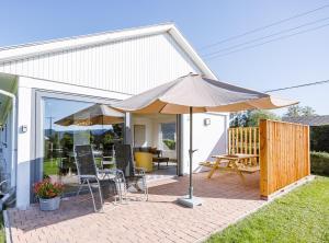 une terrasse avec un parasol, des chaises et une table dans l'établissement Chez Nat, à Rochefort