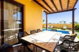 un patio con tavolo, sedie e piscina di VILLA WITH 4 BEDROOMS AND PRIVATE HEATED POOL a San Miguel de Abona