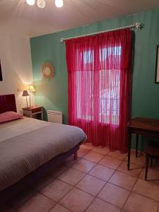 een slaapkamer met een bed en een rood gordijn bij Chambres Tricastine & Venise in Saint-Paul-Trois-Châteaux