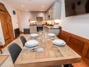 a wooden table with plates and glasses on it in a kitchen at Rockhill Farm Hay Barn in Craven Arms +14 photos