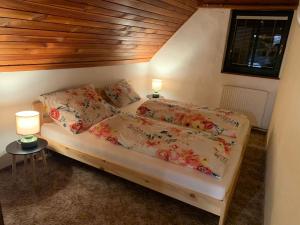 a bedroom with a bed with floral sheets and pillows at Chalupa Babí 113 in Trutnov