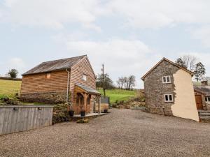 a barn and a barn house with a driveway at Rockhill Farm Wainhouse in Craven Arms