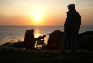 een man op een heuvel die de zonsondergang ziet bij Hotel Klippenklang in Helgoland