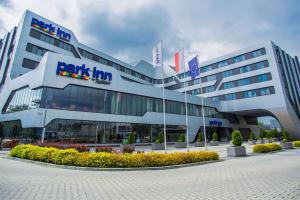 a large building with a sign on the front of it at Park Inn by Radisson Krakow in Krakow
