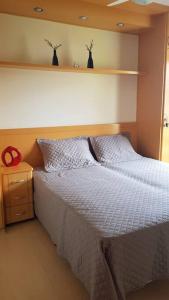 a bedroom with a bed with a white comforter at Piemonte Flat Serra Negra in Serra Negra +19 photos