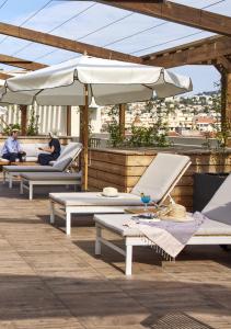 a group of lounge chairs and umbrellas on a roof at Casa Barbara Nice - Résidence Services in Nice
