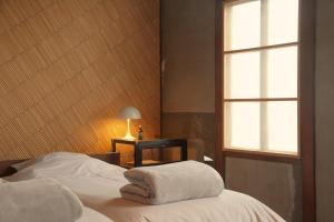 1 dormitorio con 1 cama con 2 toallas en Lhotel de Mai en Tamba-sasayama