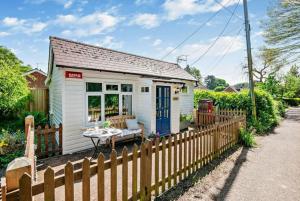 a small white cottage with a wooden fence at Cosy Cottage near Canterbury - Perfect for Couples - Dogs Welcome! in Canterbury