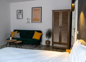 a bedroom with a green couch and a table at Cozy Studio in Sibiu