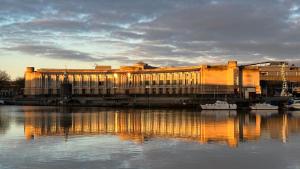 a large building sitting next to a body of water at Few remaining days available for April - book now in Bristol