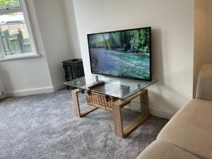 a television sitting on a table in a living room at Pentyla by StayStaycations in Port Talbot