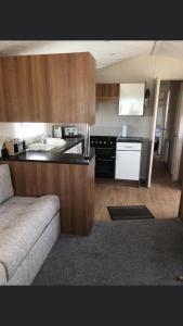 a small kitchen with a couch in a room at Jules Holiday Caravan in Hartley
