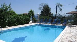 a large swimming pool with blue chairs at Nikatsas Cottage No 1 in (( Kerasá )) +14 photos