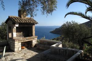 a stone fireplace with a view of the ocean at Nikatsas Cottage No 1 in (( Kerasá ))