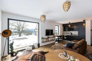 a living room with a couch and a table at Panorama Chlum Resort - Apartmán 2kk, 701 in Volary