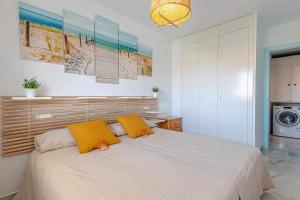 sypialnia z dużym łóżkiem z 2 żółtymi poduszkami w obiekcie 797 Holiday Rentals - Luminoso piso para 4 en Arroyo de la miel w mieście Arroyo de la Miel +25 zdjęć