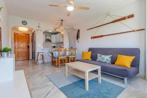 salon z fioletową kanapą i stołem w obiekcie 797 Holiday Rentals - Luminoso piso para 4 en Arroyo de la miel w mieście Arroyo de la Miel