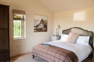 Un dormitorio con una cama grande y una ventana en Stride’s Barn, en Whiteparish