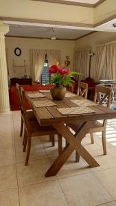 a wooden table with a bowl of flowers on it at Osh villa in Hikkaduwa