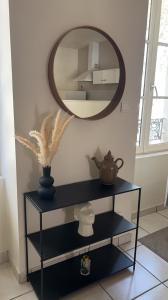 a black shelf with a mirror on a wall at Saint-Cosme Home in Chalon-sur-Saône