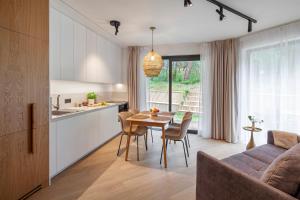 a kitchen and dining room with a table and chairs at Apartamenty na Półwyspie Wydma&Las in Jastarnia