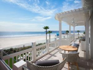 圣地亚哥Shore House at The Del, LXR Hotels & Resorts的带桌椅的阳台和海滩