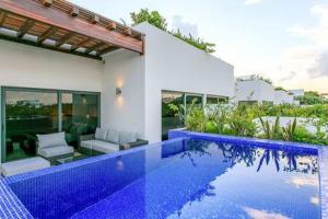 a house with a swimming pool in front of it at Gorgeous Private Pool with Terrace Steps to Beach and 5th Ave! in Playa del Carmen