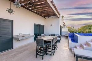 eine Terrasse mit einem Tisch, Stühlen und einem Waschbecken in der Unterkunft Gorgeous Private Pool with Terrace Steps to Beach and 5th Ave! in Playa del Carmen