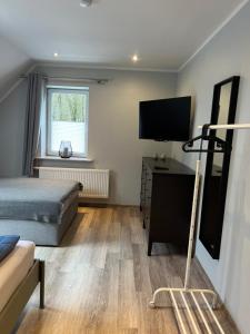 a bedroom with a bed and a desk with a television at Ferienwohnungen Margot in Iserlohn